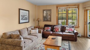 A living room with two sofas, a coffee table, a lamp, and framed artwork on the walls. - Dakota Lodge #8517 (Keystone)
