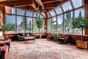 A spacious room with large windows, leather sofas, a patterned carpet, and wooden accents. - Br13100b (Breckenridge)