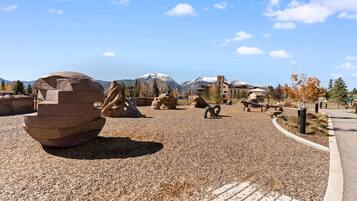 A gravel area with large rock formations and a mountain in the background.
