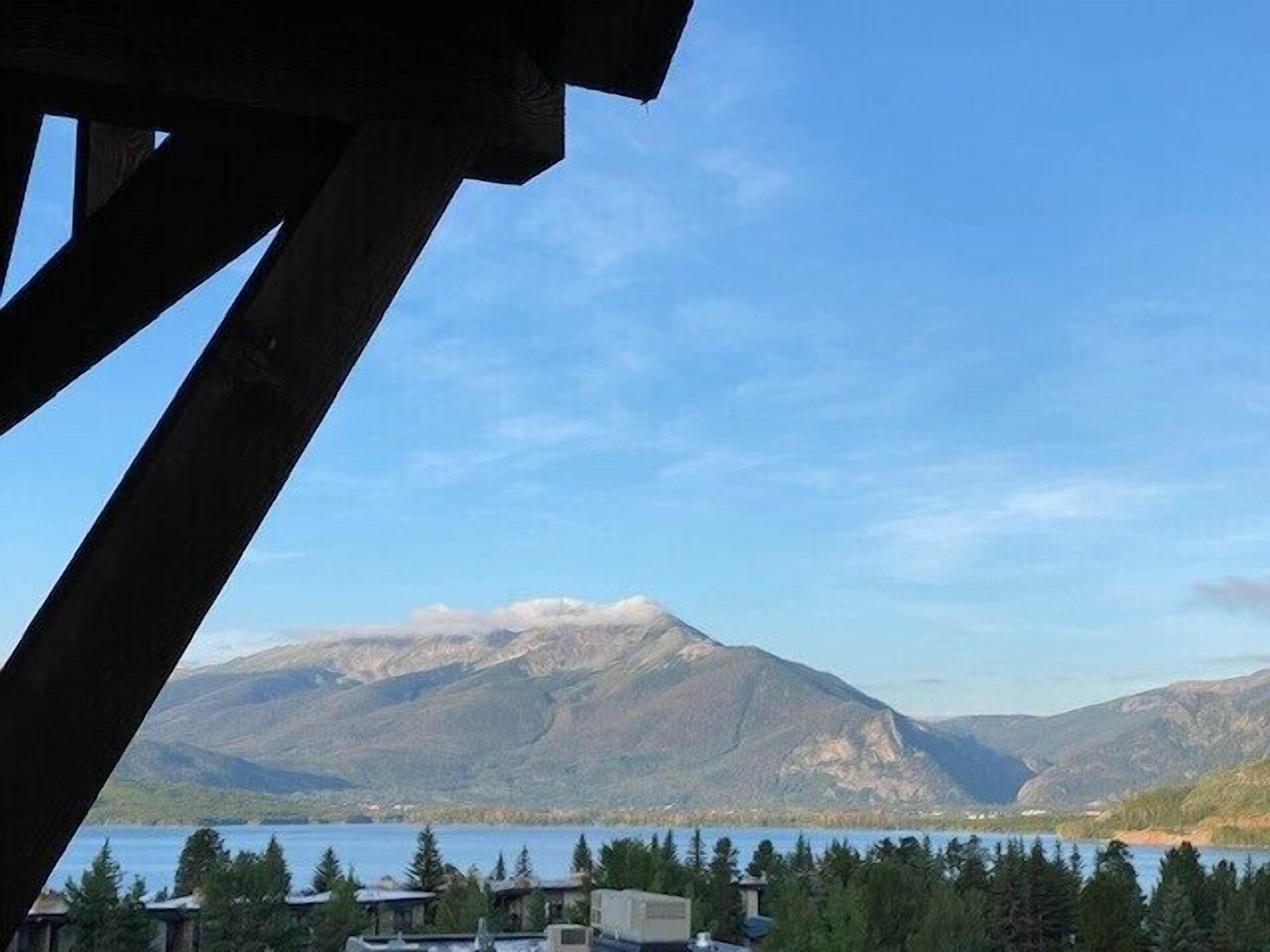 A mountain view with a lake and forested area.