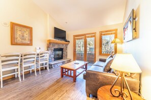 A living room with a fireplace, wooden furniture, and a television. - Al8134-2 (Keystone)