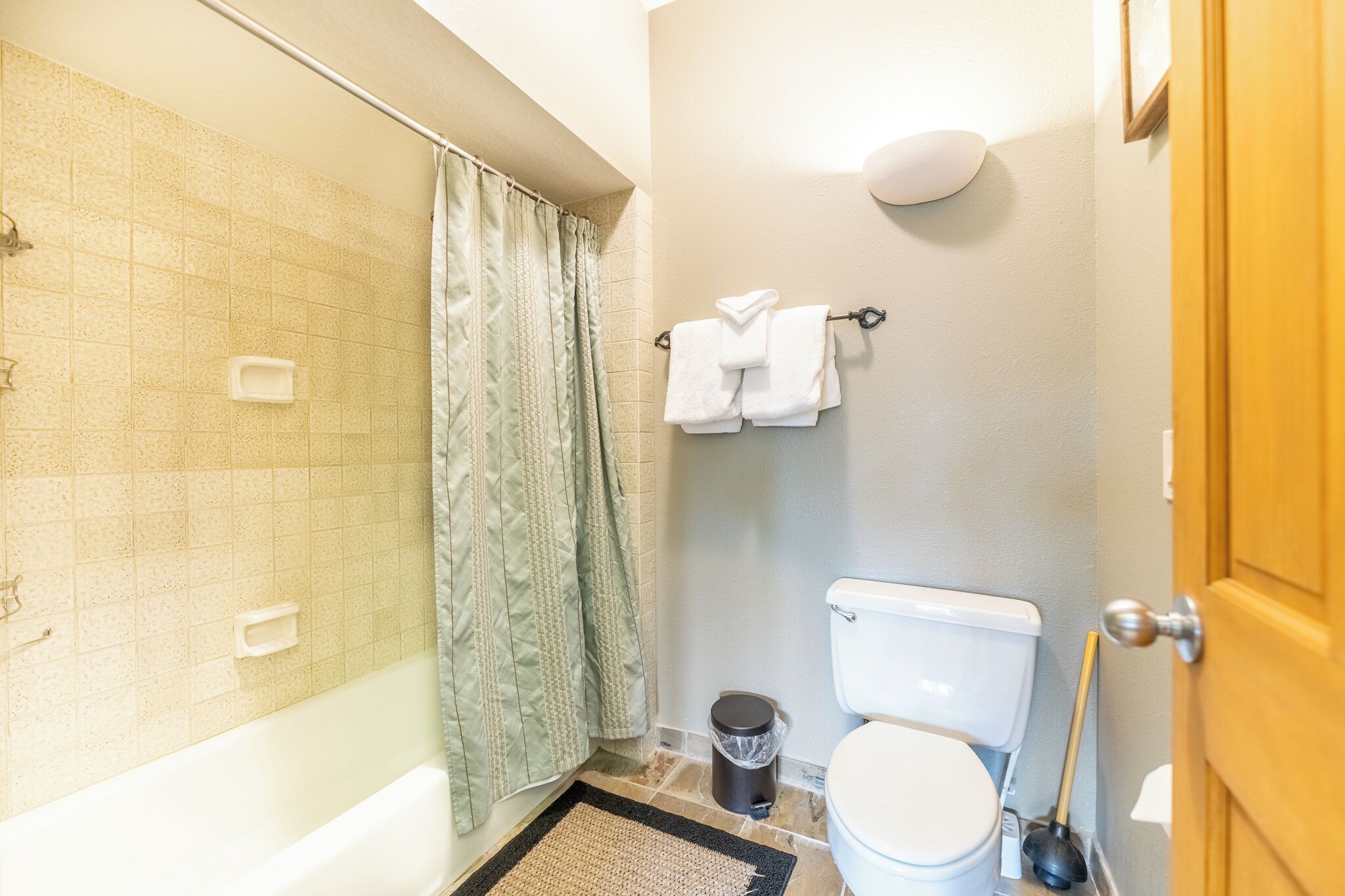 A bathroom with a shower, toilet, and a towel rack.