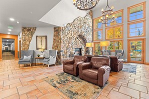 Eine Lobby mit Steinwand, Ledersofas und Kamin.
