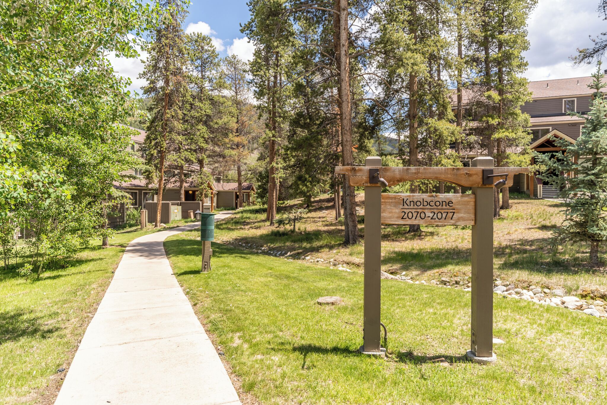 A pathway leading to a building with a sign reading "Knobcone 2070-2077".