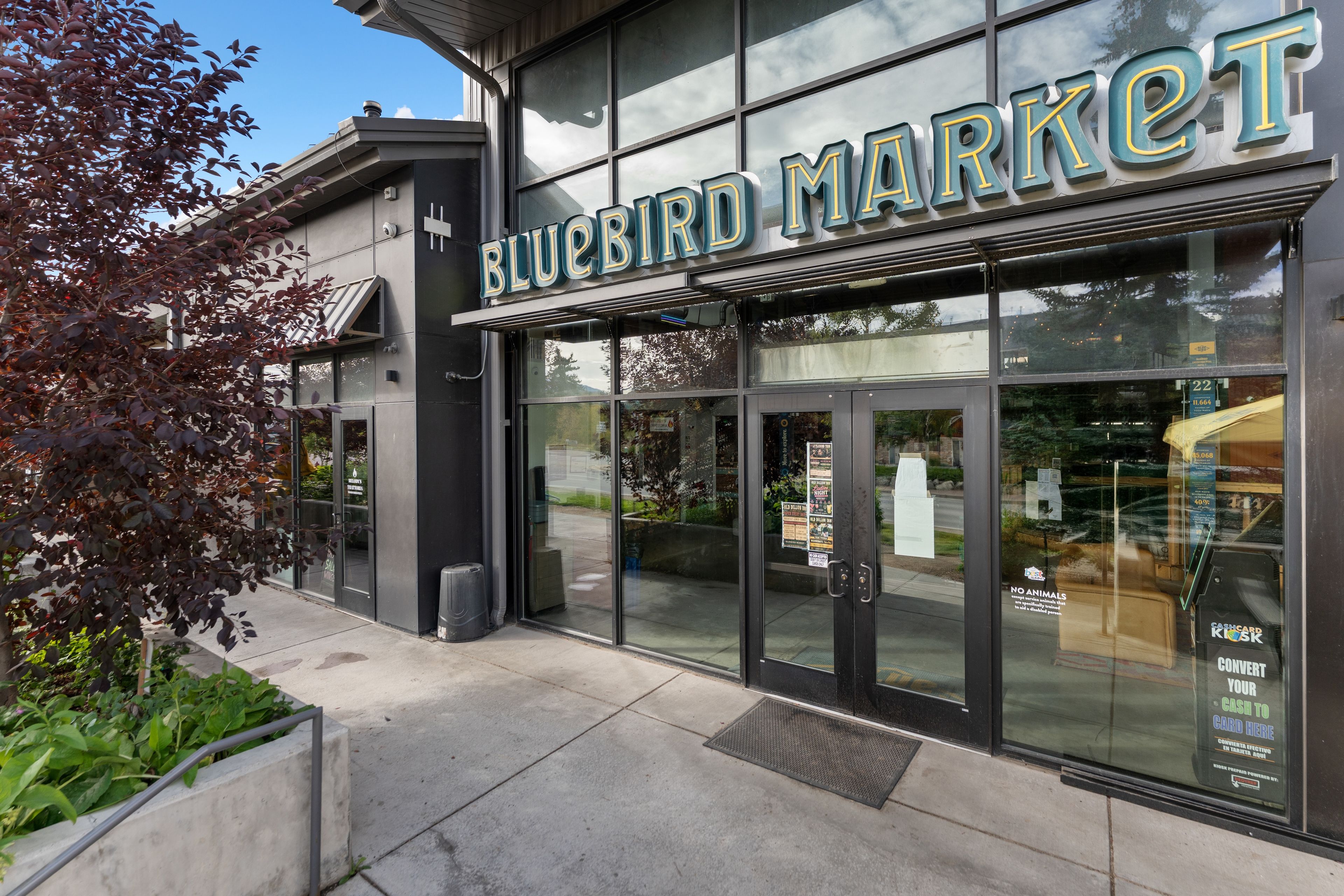 A storefront with a large sign reading 'BLUEBIRD MARKET'.