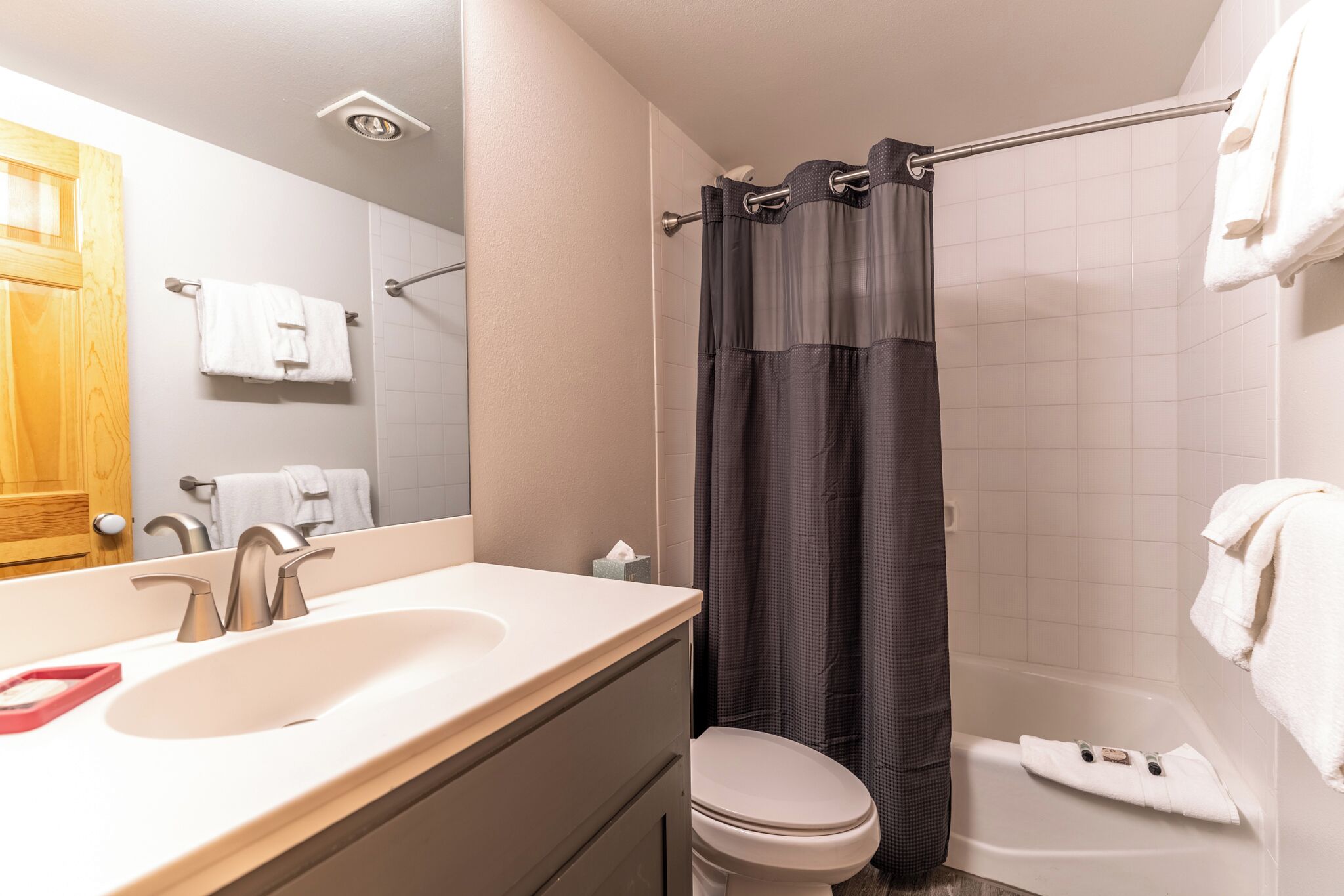 A bathroom with a sink, toilet, and shower curtain.