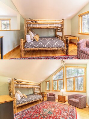 A rustic-style room with a loft bed, a small table, a chair, and a large window. - 45fmnl-5 (Keystone)