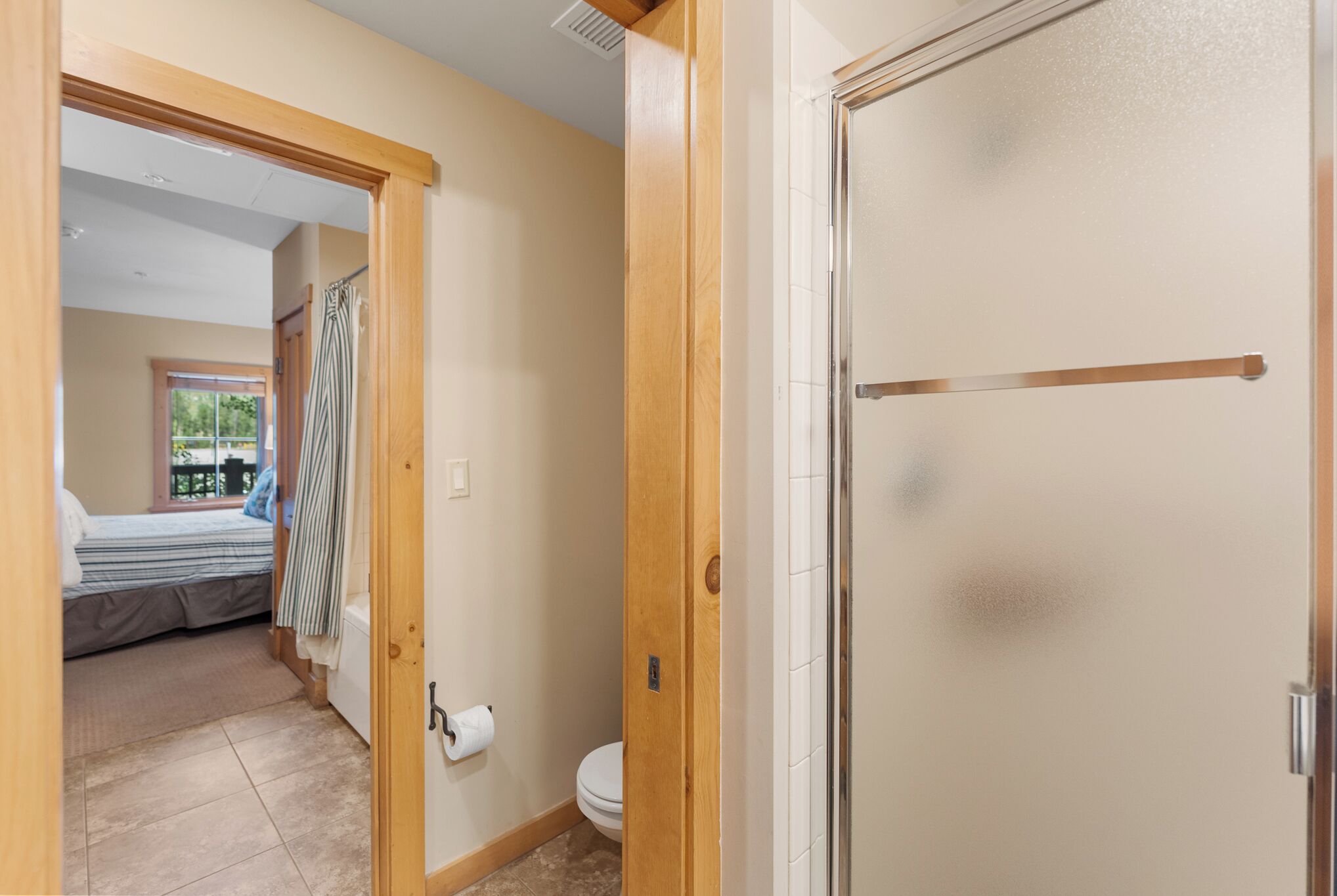 A room with a bed, a toilet, and a shower area.