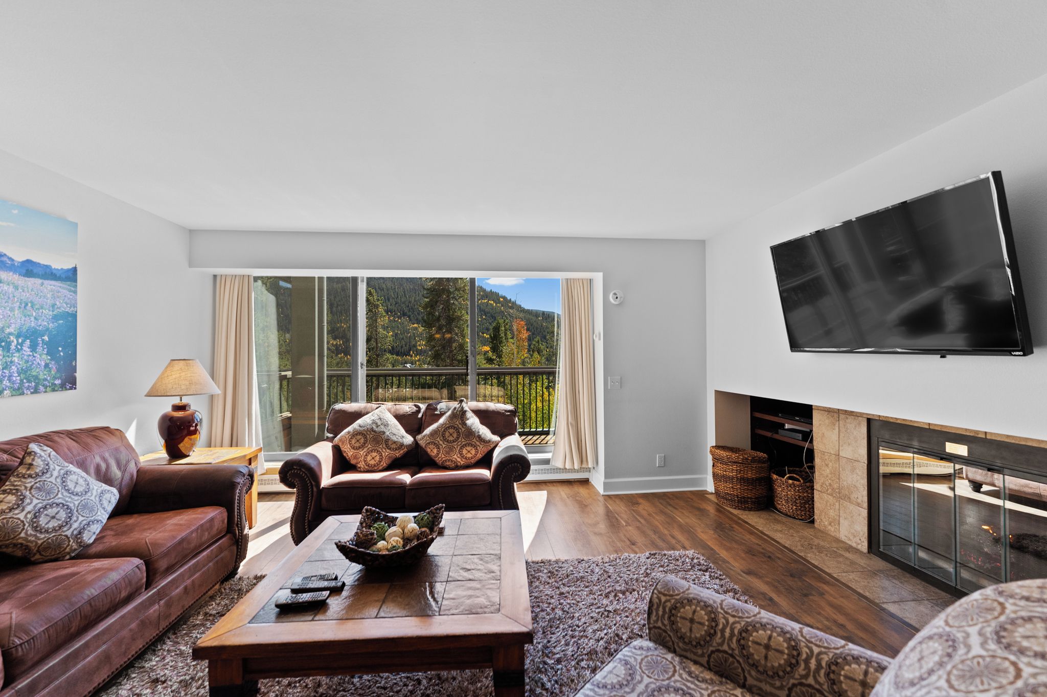 A modern living room with a sofa set, a coffee table, and a fireplace.