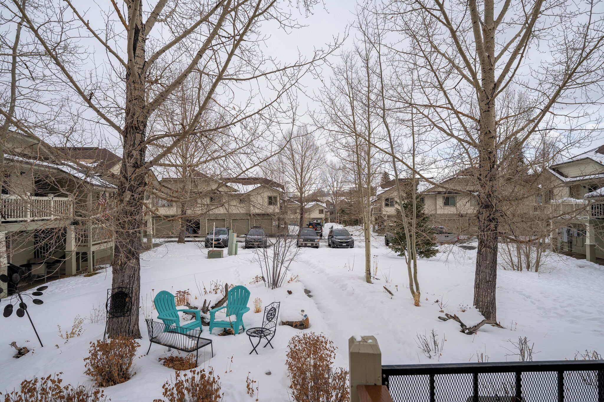 A residential area with houses, a snow-covered yard, and outdoor seating.
