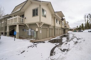 A multi-story building with a balcony on the second floor, a 'No Parking' sign, and a snow-covered ground. - Ppt202f3 (Frisco)