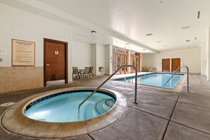 Une piscine intérieure avec une porte en bois et un panneau sur le mur.