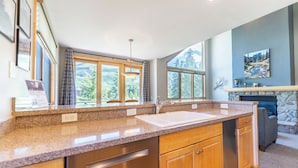 A modern kitchen with granite countertops, stainless steel appliances, and large windows offering a view of the outdoors. - Iw2997-3 (Keystone)