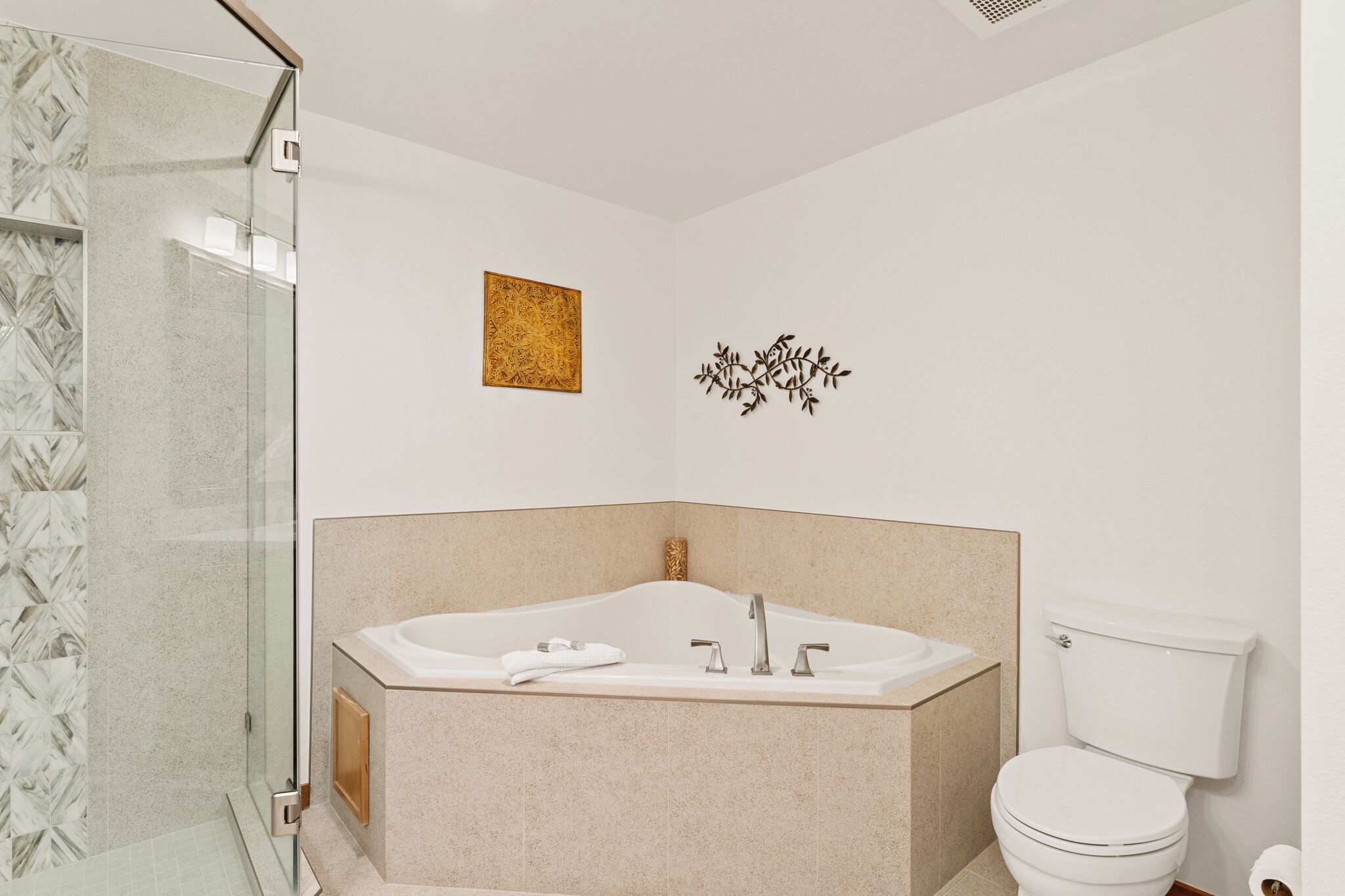A modern bathroom with a freestanding bathtub, a glass shower enclosure, and a toilet.