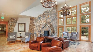 A spacious lobby with a stone fireplace, leather sofas, and large windows offering natural light. - Expedition Station #8581 (Keystone)
