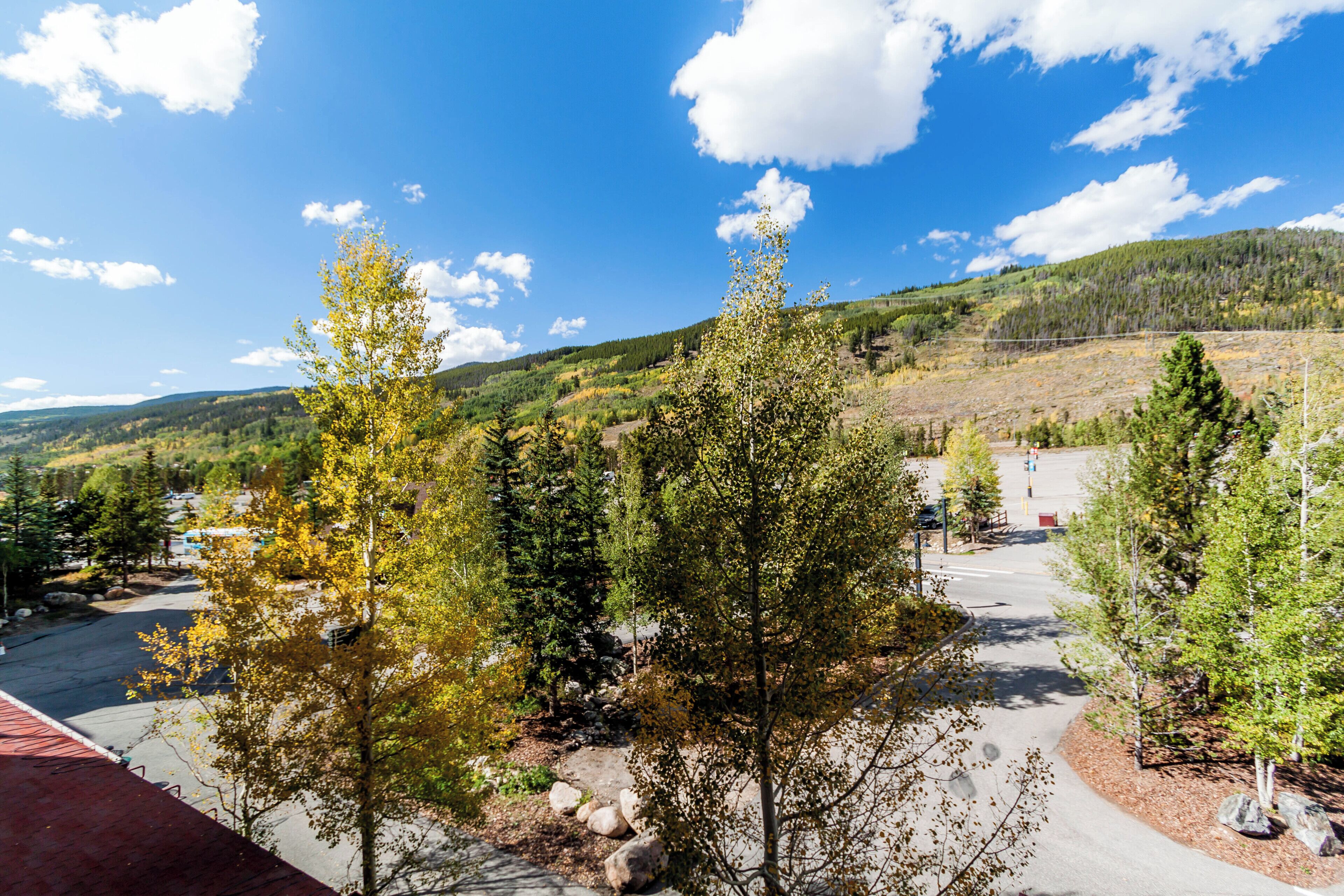 A parking area with trees and a view of a hilly landscape.