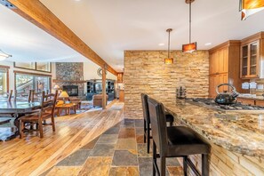 A spacious kitchen with a large island, wooden cabinets, and a stone accent wall.