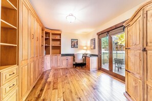 Une cuisine spacieuse avec des meubles de rangement en bois, un plan de travail et une vue sur la terrasse extérieure.