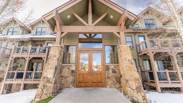 Un immeuble à plusieurs étages, doté d’une façade en pierre, d’une porte d’entrée en bois et d’un balcon.