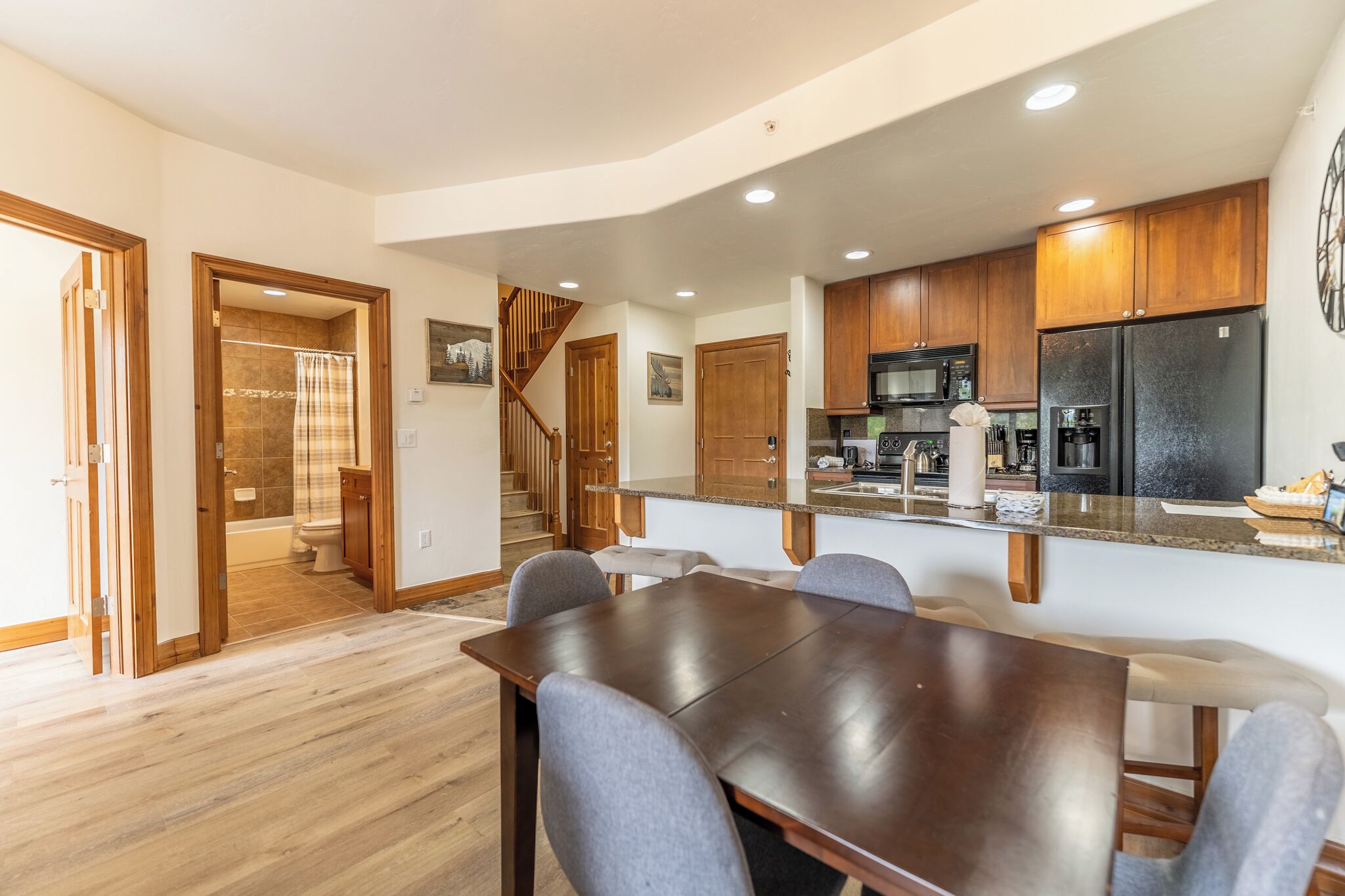 A modern kitchen with wooden cabinets, a stainless steel refrigerator, and a built-in microwave.