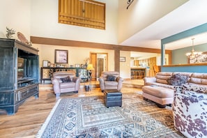 A spacious living room with a large rug, leather sofas, and a television. - E6-4 (Keystone)