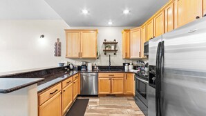 A modern kitchen with wooden cabinets, stainless steel appliances, and a granite countertop. - Lrd204d2 (Dillon)