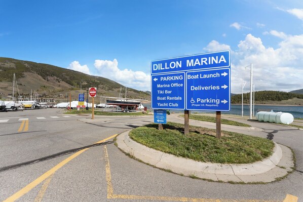 Señal de puerto deportivo con indicaciones hacia el estacionamiento, rampa para embarcaciones, entregas y un club náutico.