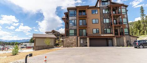 A multi-story building with a modern architectural design, featuring balconies and large windows.