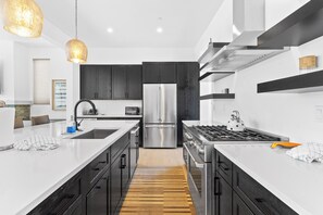 A modern kitchen with a central island, stainless steel appliances, and a wooden floor. - Sb30s4 (Silverthorne)