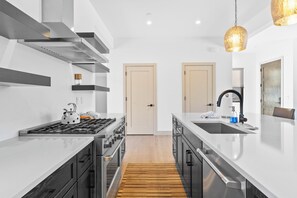 A modern kitchen with a central island, stainless steel appliances, and a wooden floor. - Sb30s4 (Silverthorne)