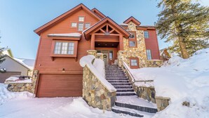 A two-story house with a stone staircase leading to the front door, surrounded by snow. - 94rgrs4 (Silverthorne)