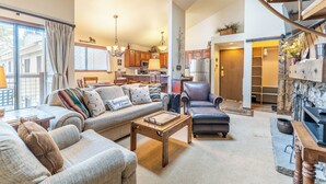 A spacious living room with a sofa, coffee table, and a fireplace.
