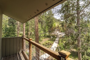 Ein Balkon mit Blick auf ein bewaldetes Gebiet und einen befestigten Weg.