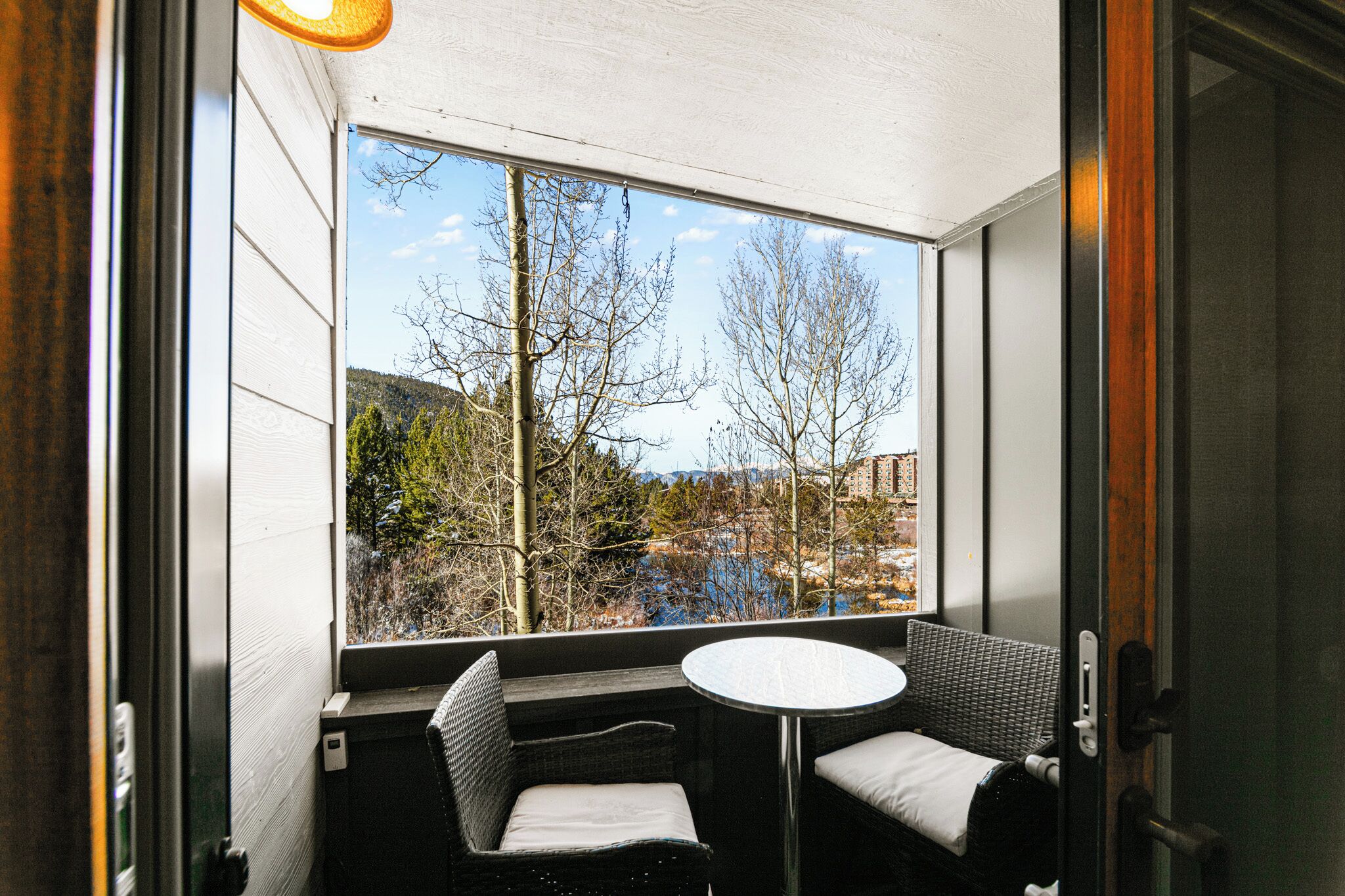 A room with a large window, a round table, and two chairs.