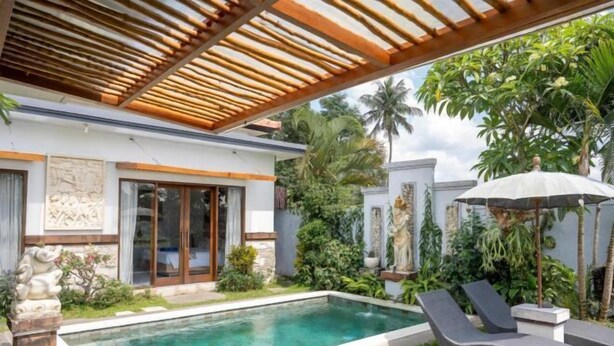 A modern pool area with a clear pool, lounge chairs, and a pergola. - Villa d'Alas Ubud (Bali)