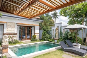 A modern pool area with a clear pool, lounge chairs, and a pergola. - Villa d'Alas Ubud (Bali)