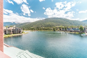 A lakeside view with buildings and a mountain in the background.