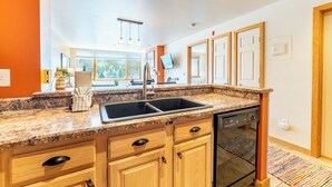 A modern kitchen with granite countertops, wooden cabinets, a double sink, and a dishwasher. - La1540-1 (Keystone)