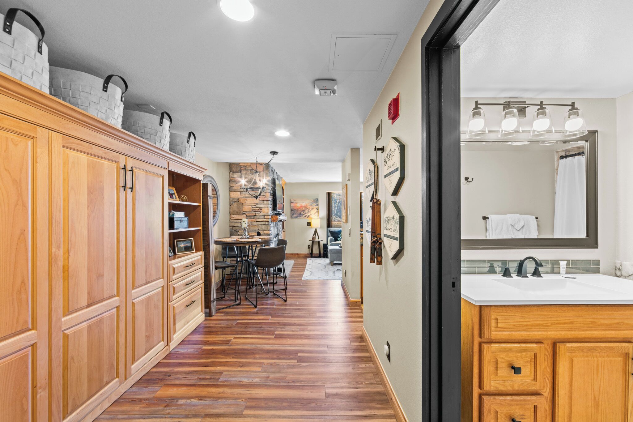 A spacious kitchen with wooden cabinets, a dining area with chairs, and a view into the dining room.
