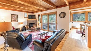 A spacious living room with a fireplace, leather sofas, and a dining area with a wooden table and chairs. - Tt1340-3 (Keystone)