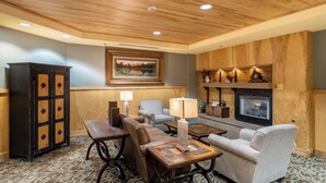 A cozy lounge area with wooden paneling, a fireplace, and comfortable seating. - Silver Mill #8220 (Keystone)