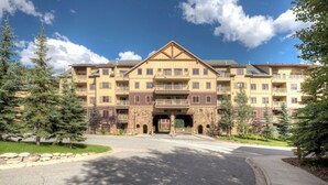 A multi-story building with a central entrance, balconies, and a stone facade. - Red Hawk Lodge #2235 (Keystone)