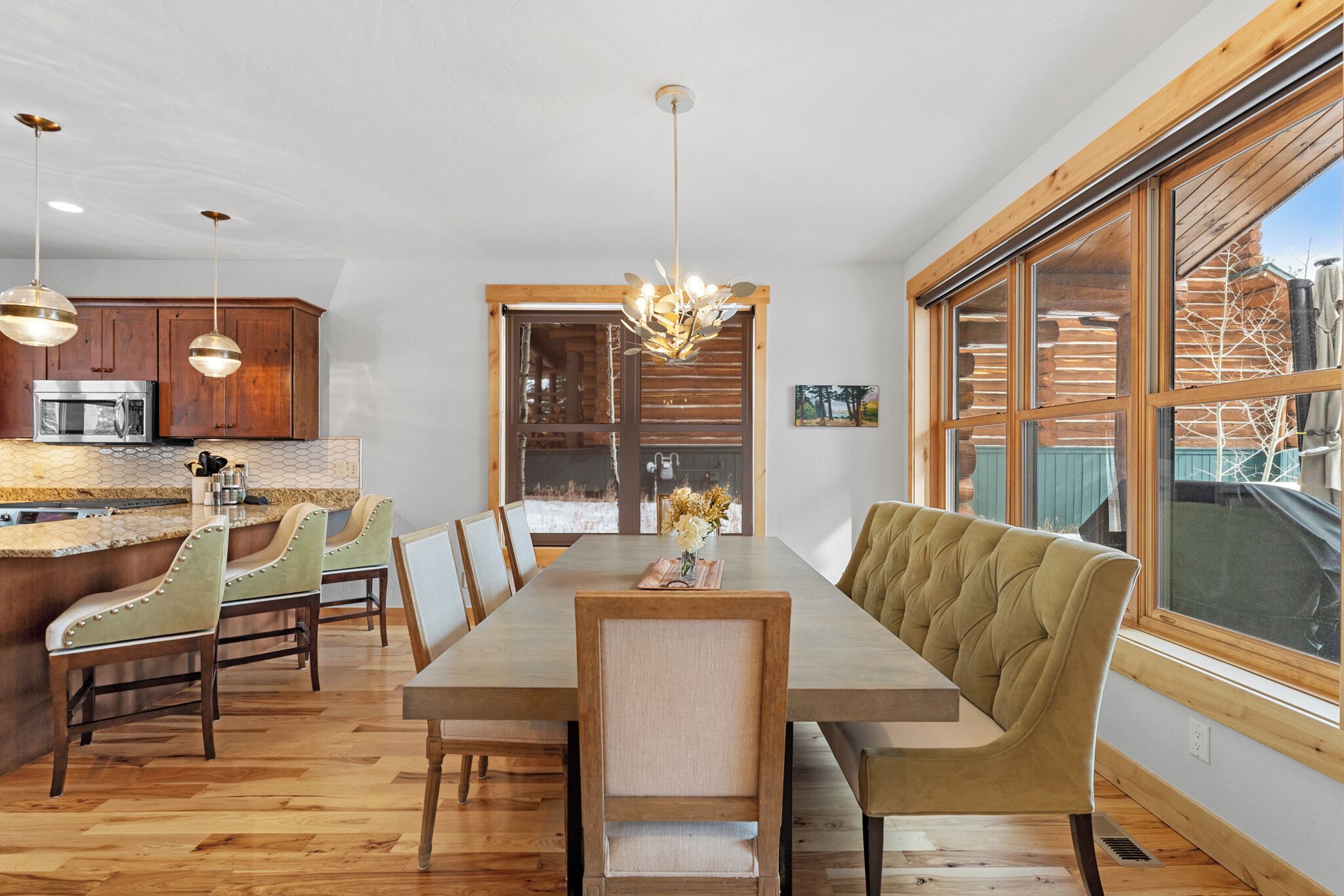 A modern kitchen with wooden cabinets, a built-in microwave, and pendant lights.