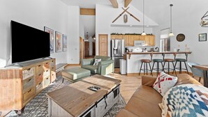 A spacious living room with a large TV, wooden furniture, and a cozy seating area. - Retreat on the Blue, Unit E2 : 150 (Silverthorne)