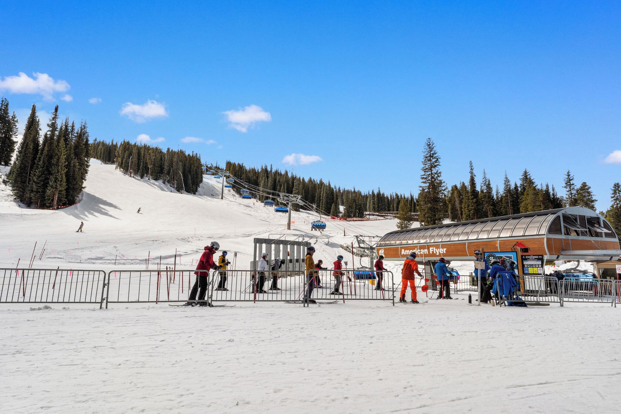 A ski resort with a ski lift, a lodge, and a snow-covered slope.