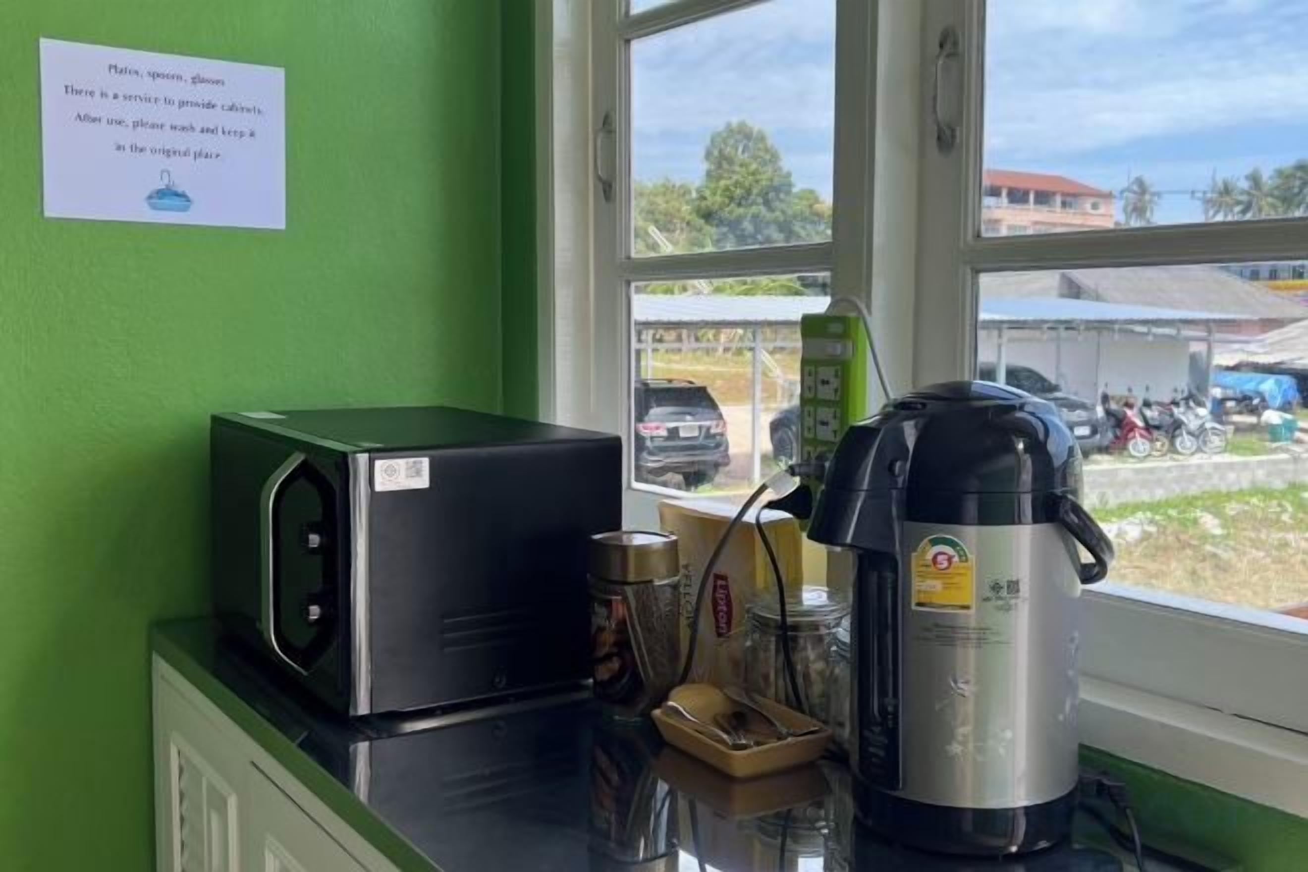 A kitchen counter with a microwave, a coffee maker, and a kettle.