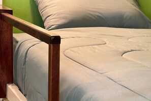 A bed with a wooden headboard and a light-colored mattress.
