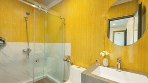 A bathroom with a glass shower enclosure, a white toilet, a sink with a marble countertop, and a mirror. - Hanoi Old quarter Central Hotel (Hanoi)
