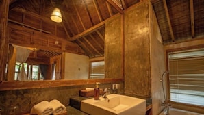 A rustic bathroom with a large mirror, wooden ceiling, and a bathtub. - Bije Suite Villa Ubud (Bali)