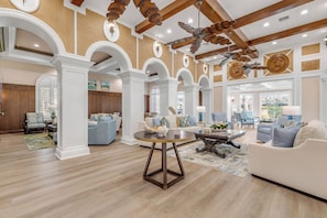 A spacious living room with high ceilings, wooden beams, and a large ceiling fan. - Beachfront Bliss by the Surf | Inlet #605 (New Smyrna Beach)